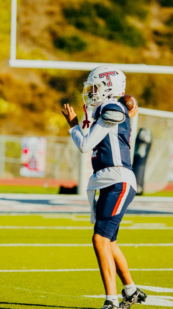 Side view of Jayden Hansen holding the football near his throwing shoulder — 2025 freshman season